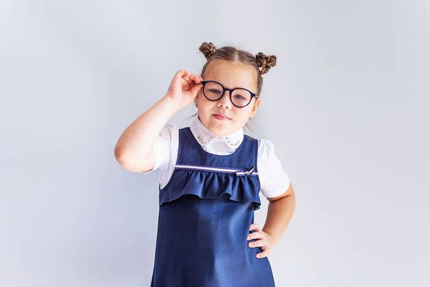 A beautiful little brunette girl looks at the camera trying on glasses. Vision correction. Ophthalmology. - Fotó, kép