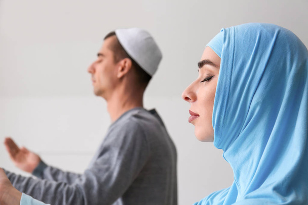Мусульманская пара молится в комнате
 - Фото, изображение