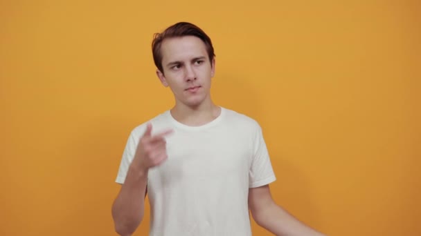 Mann im weißen T-Shirt zeigt Geste, von der er denkt, dass sie Zeigefinger an Kopf berührt - Filmmaterial, Video