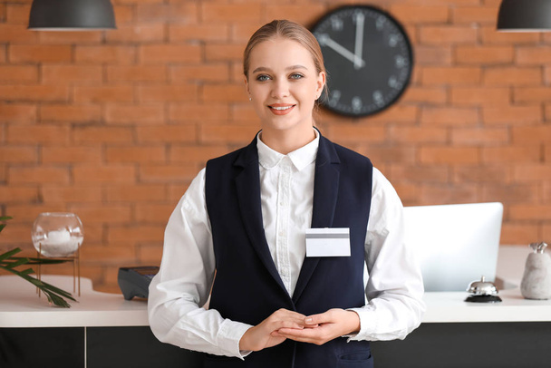 Young female receptionist near desk in hotel - Foto, Imagem