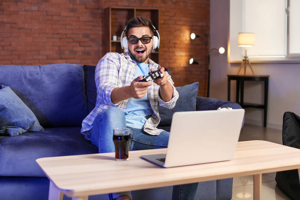 Fiatal férfi játszik videojáték otthon - Fotó, kép