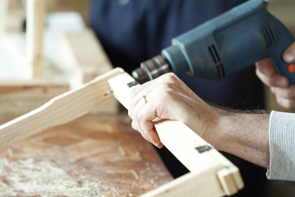Man's arms drill lath in the workshop. - Фото, изображение