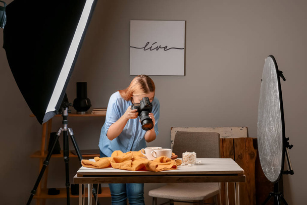 Jovem mulher tirando foto de bebida com marshmallows em estúdio profissional
 - Foto, Imagem