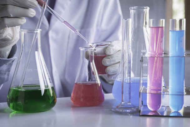 Исследователь со стеклянными лабораторными химическими пробирками с жидкостью
 - Фото, изображение