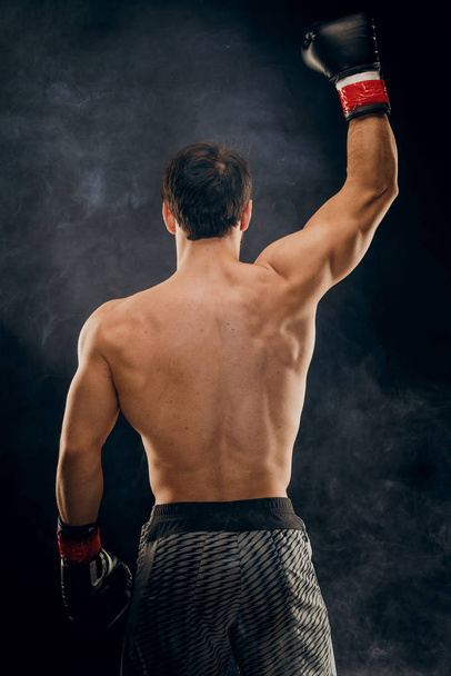 Vista posterior del hombre boxeador con las manos levantadas en gesto de victoria. Con
 - Foto, imagen