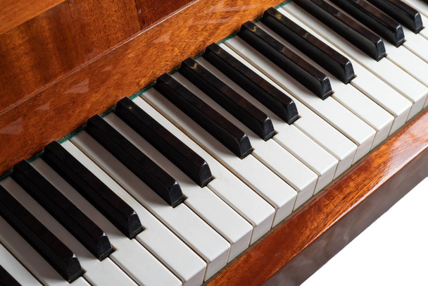 Клавиатура коричневого фортепиано на белом фоне. Селективный фокус
.  - Фото, изображение