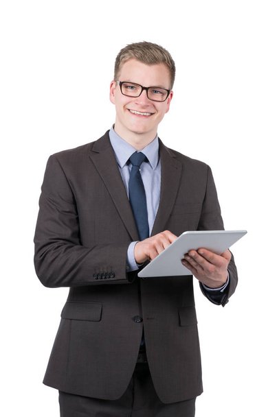 full-time photo of a young,smiling businessman who uses a tablet. the man looking to camera. - Zdjęcie, obraz