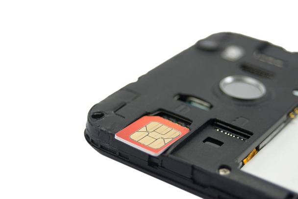 SIM card close-up next to the connector in the smartphone, phone isolated on white background - Foto, Bild