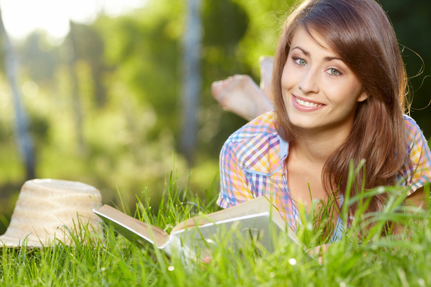 female student lying on the grass with a books - Foto, Bild