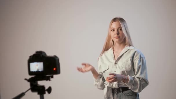νεαρή κοπέλα μαγνητοσκόπηση βίντεο για το μακιγιάζ με φωτογραφική μηχανή επισυνάπτεται σε τρίποδο - Πλάνα, βίντεο
