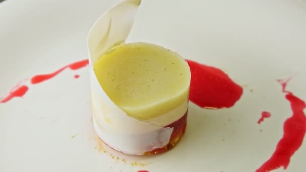 Nahaufnahme exquisit dekoriertes mehrschichtiges Mousse-Dessert dreht sich auf Teller - Filmmaterial, Video
