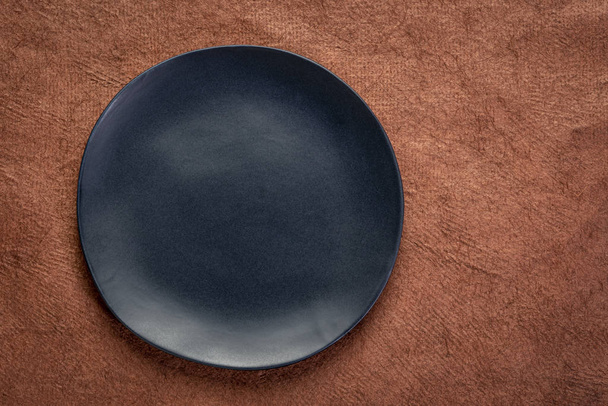 black plate on textured handmade paper - Fotó, kép