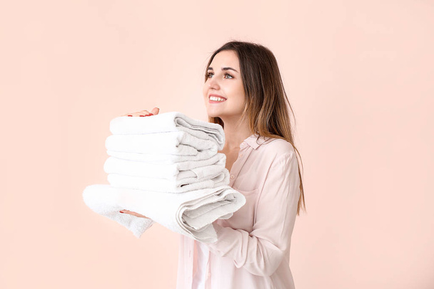 Beautiful young woman with laundry on color background - Fotoğraf, Görsel