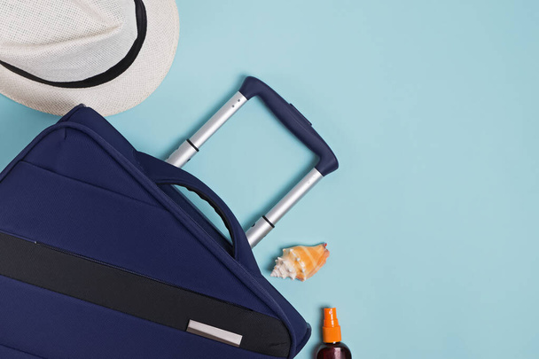 Suitcase, passport and hat on blue background - Fotoğraf, Görsel