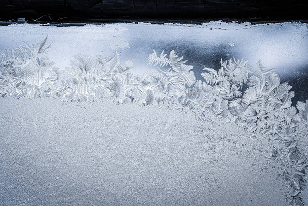 Frosty natuurlijk patroon op winterraam, decoratieve vorst op het glas. - Foto, afbeelding