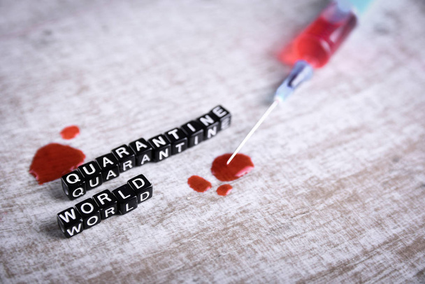 Concept d'analyse de sang de coronavirus Wuhan, Chine 2020.Masque respiratoire avec une trace de sang, seringue et inscription monde de quarantaine.
. - Photo, image