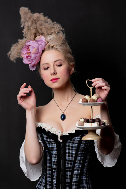 Όμορφη ξανθιά κόμισσα με καραμέλες σοκολάτας  - Φωτογραφία, εικόνα