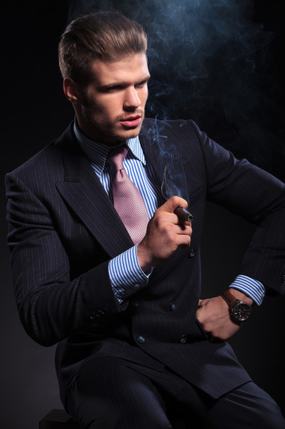 άνθρωπος των επιχειρήσεων μόδας καπνίζοντας ένα πούρο και κοιτώντας μακριά - Φωτογραφία, εικόνα