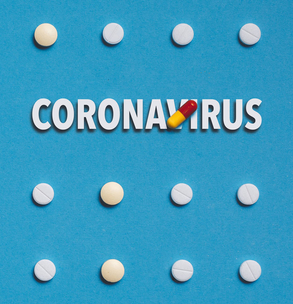 Outbreak of coronavirus infection 2019-nCoV in China idea. Vaccine development drugs, Colored Pill On Blue Background  - Фото, изображение