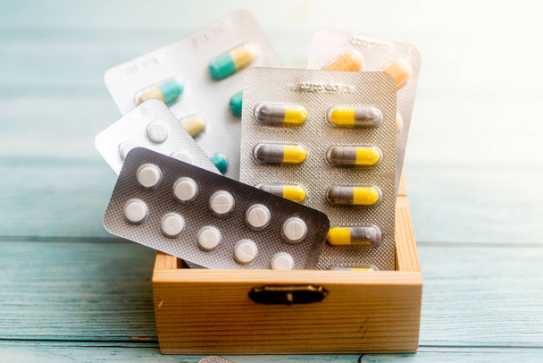 Лікарські таблетки в дерев'яній коробці на дерев'яному фоні. Долина де - Фото, зображення