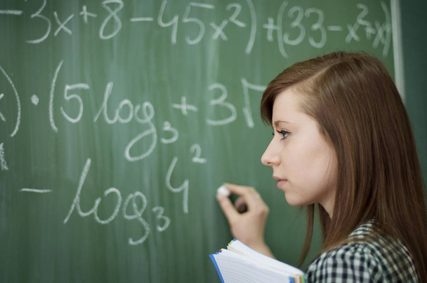 Student girl writing mathematical formula - Fotó, kép