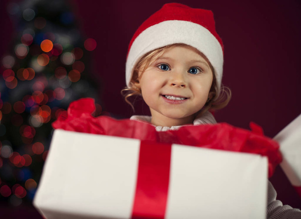 Santa little girl opening christmas present - 写真・画像
