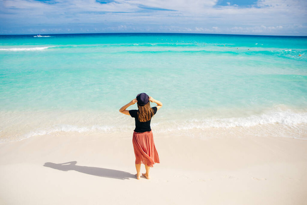 Okyanusun arka planında şapkalı bir kız. Güzel kız denize bakıyor..  - Fotoğraf, Görsel