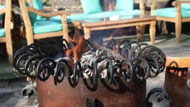 Καύση καυσόξυλων σε διακοσμητικό θερμοσίφωνα σε μεσογειακό εστιατόριο σε θερμούς τουρίστες ή επισκέπτες κατά τη διάρκεια της κρύας χειμερινής περιόδου. Φωτιά σε μοντέρνο μεταλλικό φούρνο με ξύλινα ράφια. Hd βίντεο αργή κίνηση - Πλάνα, βίντεο