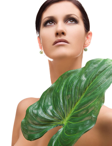 picture of woman with green leaf over white - Foto, afbeelding