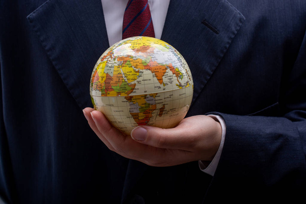 Man holding an earth globe model in his hands - Zdjęcie, obraz