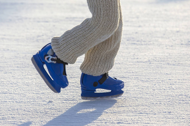 legs of a man in blue skates rides on an ice rink. Hobbies and s - Photo, Image