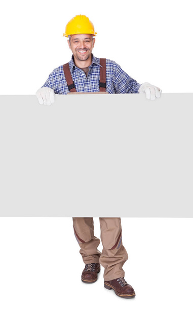 Portrait Of Happy Contractor Holding Placard On White Background - Φωτογραφία, εικόνα
