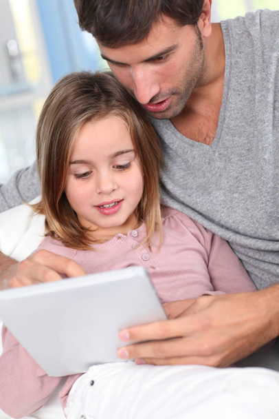 Father and child using electronic tablet at home - Foto, immagini