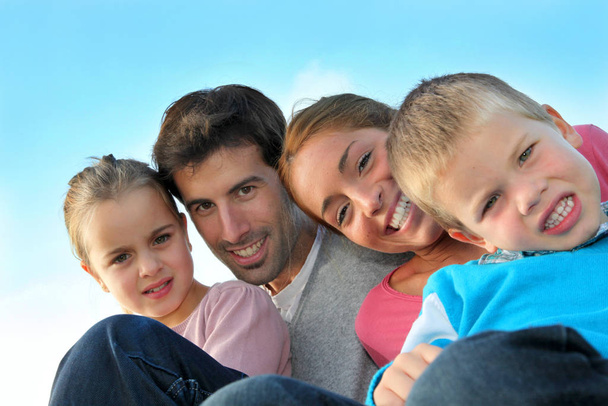 Portrait of happy family sitting outdoors - Foto, imagen
