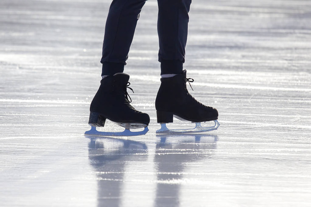pies en los patines de una persona rodando en la pista de hielo - Foto, Imagen