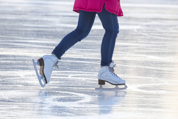 piernas de una chica patinando sobre hielo en una pista de hielo. Pasatiempos y deportes. V.
 - Foto, Imagen