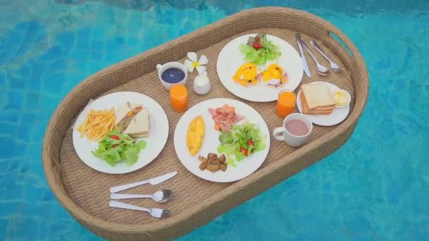 primer plano de la composición de la deliciosa comida en bandeja flotante en la piscina - Metraje, vídeo