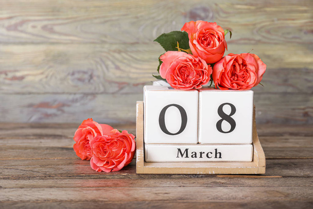 Calendar with date of International Women's Day and flowers on wooden background - Φωτογραφία, εικόνα