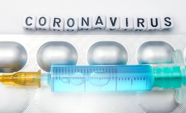Новий коронавірус - концепція 2019-nCoV, шприц і таблетки ізольовані на білому
 - Фото, зображення
