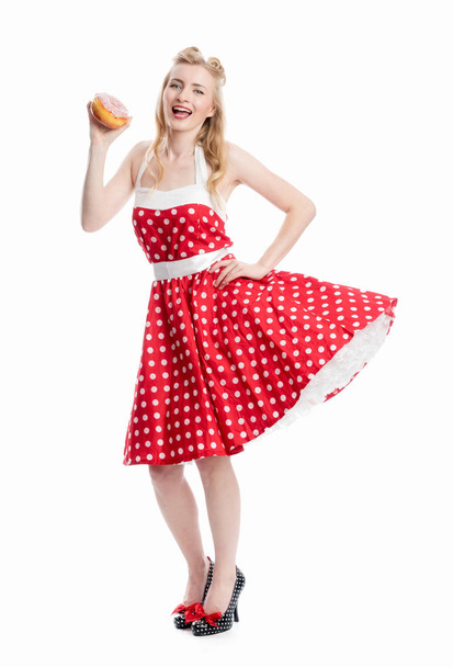 a woman in rockabilly style is holding a bagel - Foto, Imagem