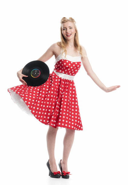 a woman in rockabilly style holds vinyl records as a advertising surface - Foto, Bild