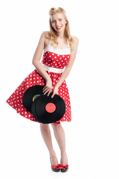 a woman in rockabilly style holds vinyl records as an advertising space  - Foto, imagen