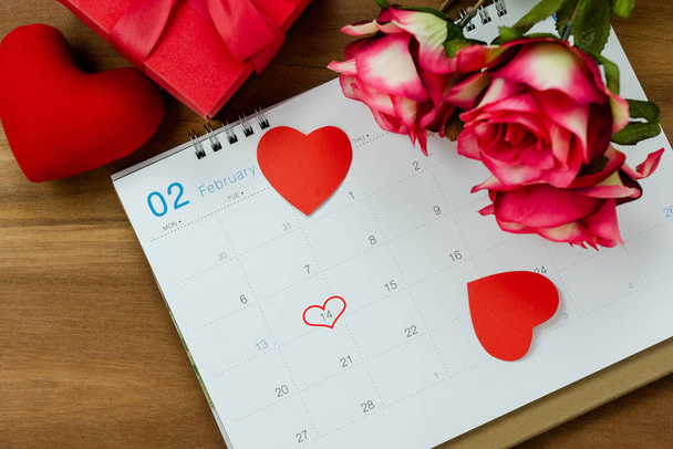 Asztali nézet légi kép dekoráció valentin napi háttér koncepció.Lapos elrendezése naptári oldal februári hónap alapvető elemeket szerelem szív rózsa virág fán. - Fotó, kép