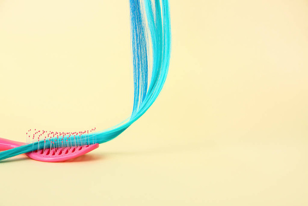 Blue hair strand and brush on color background - Fotoğraf, Görsel