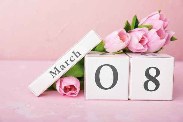 Calendário com data do Dia Internacional da Mulher e flores na mesa
 - Foto, Imagem