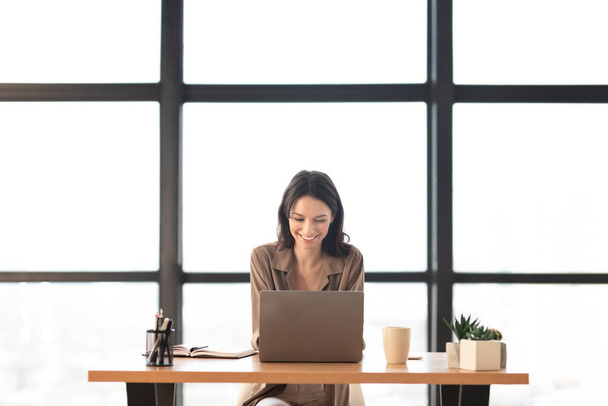 schönes Mädchen arbeitet an ihrem Laptop im modernen Büro - Foto, Bild