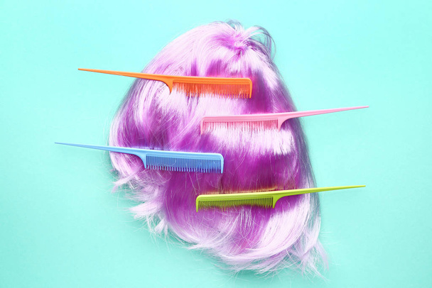Unusual wig and combs on color background - Fotó, kép