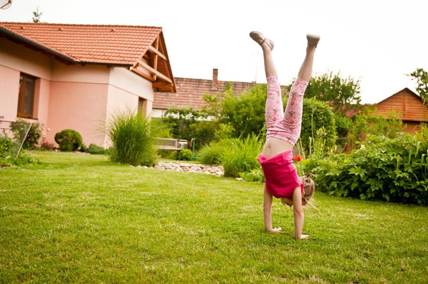 Child doing handstand in backyard - Φωτογραφία, εικόνα