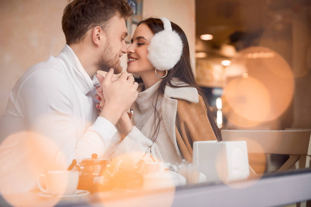 glückliches junges Paar sitzt im Café, Blick durch Glasfenster - Foto, Bild