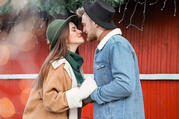 Happy young couple on Christmas fair outdoors - Photo, Image
